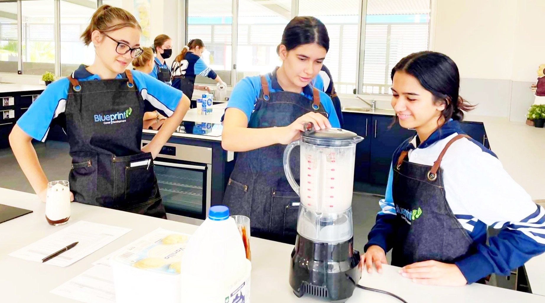 Students in aprons learning kitchen skills