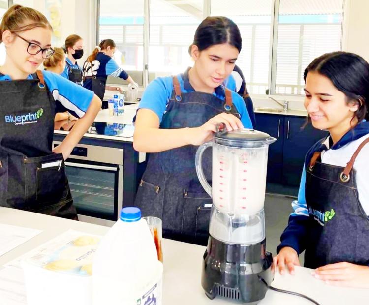 Students in aprons learning kitchen skills