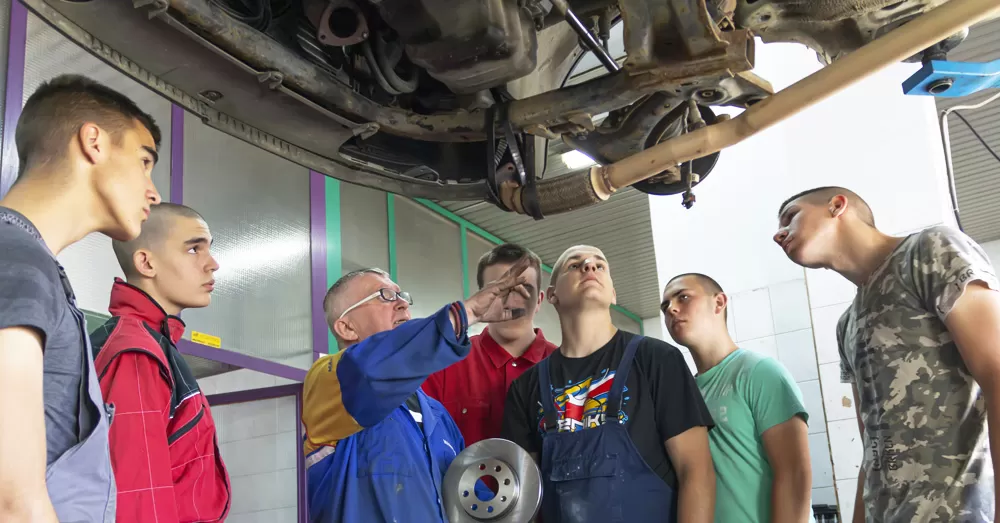 TAE40122 Certificate IV in Training and Assessment students observing a trainer deliver hands-on automotive training — ideal for tradies and VET professionals looking to become qualified workplace trainers or assessors.