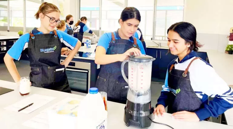 Students in aprons learning kitchen skills
